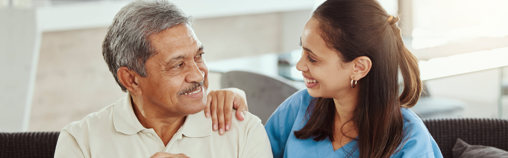 caregiver and senior man sitting in the sofa