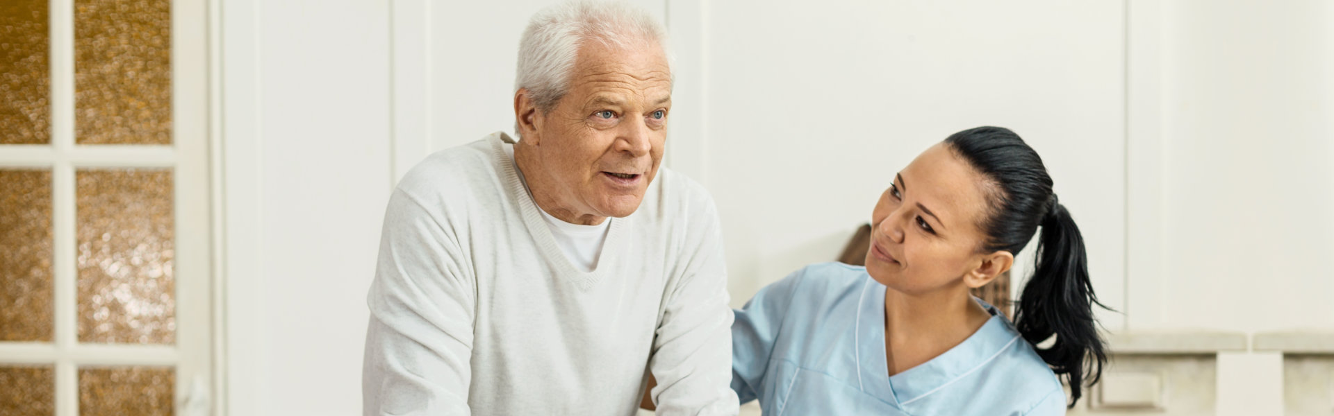 caregiver assisting senior man while walking