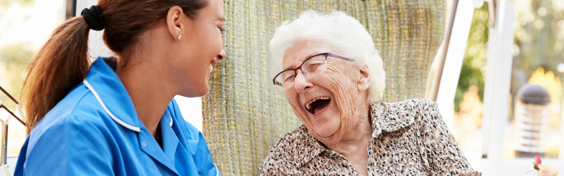 caregiver and senior woman laughing