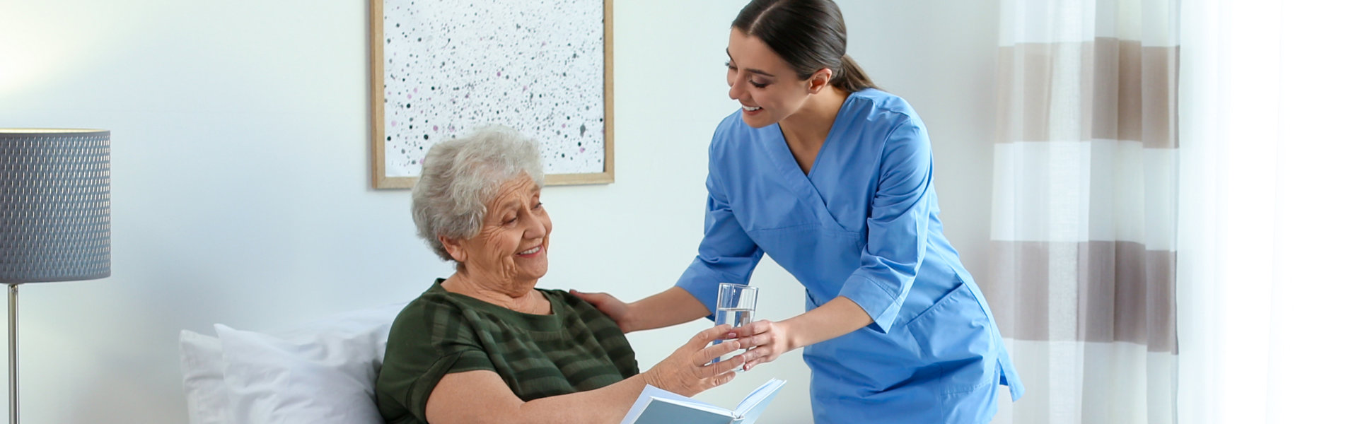 caregiver giving water to the senior woman