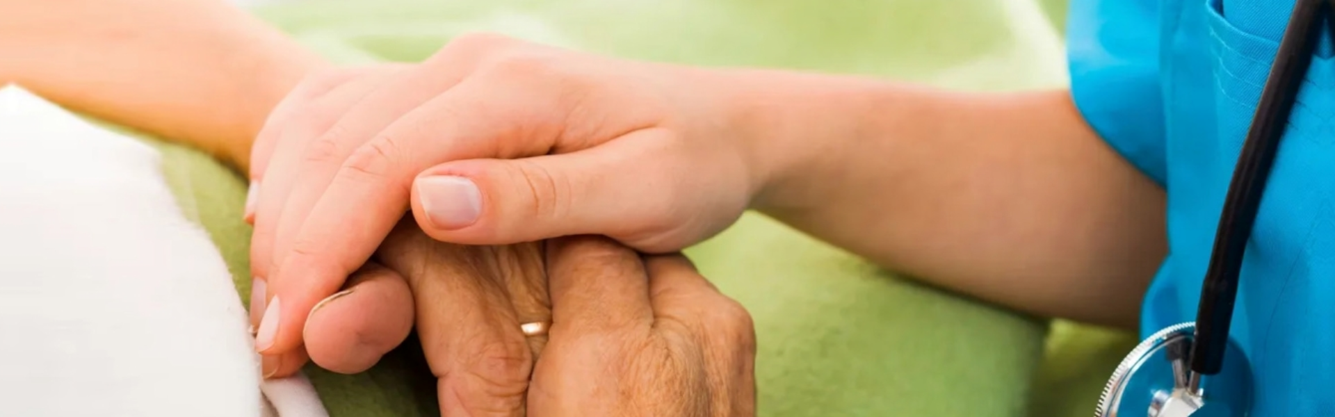 elderly woman holding hands with caregiver